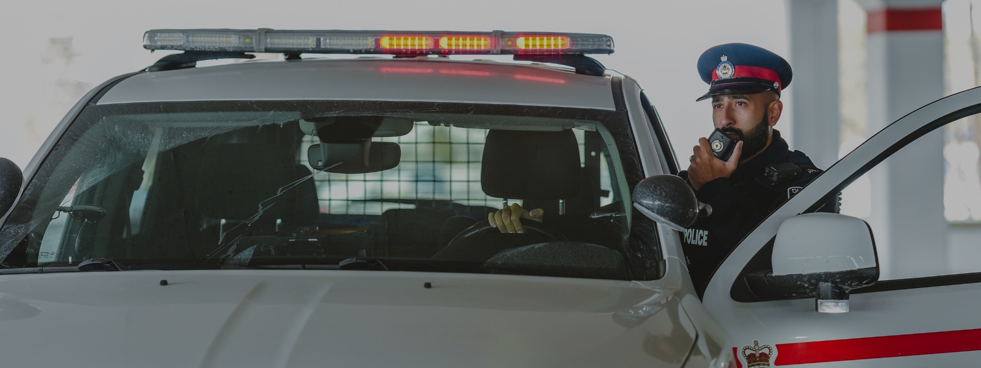 Officer standing outside the police cruiser on his radio